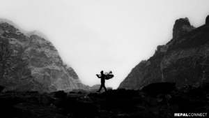 Silhouette of Sherpa in a rugged mountain landscape.