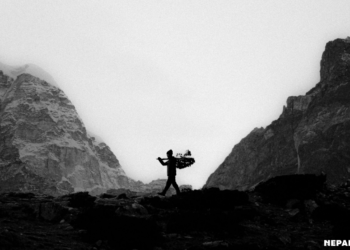 Silhouette of Sherpa in a rugged mountain landscape.