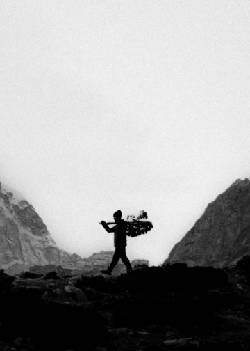 Silhouette of Sherpa in a rugged mountain landscape.
