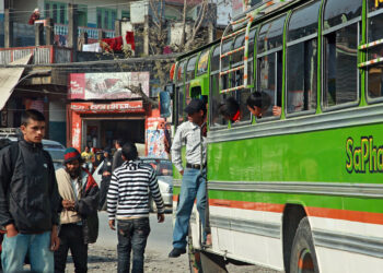 A passenger disembarks from a bus
